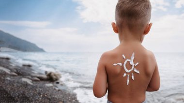 Güneş kreminden yapılmış güneş kremi desenli bir erkek omzunun yakın çekimi. Bebek derisi hakkında koruma.