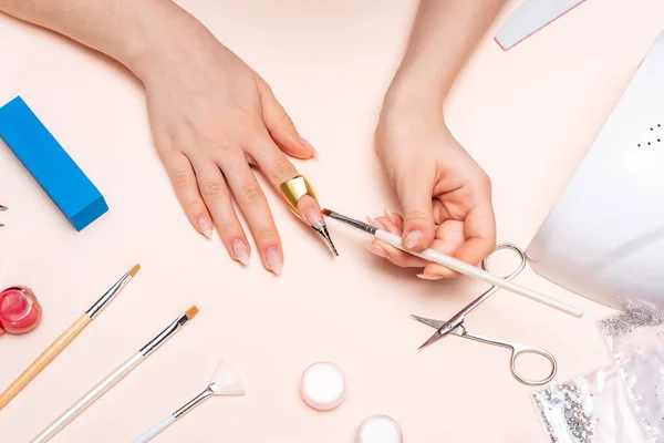 Uma menina fazendo uma manicure em casa, mãos de perto. a vista do topo — Fotografia de Stock