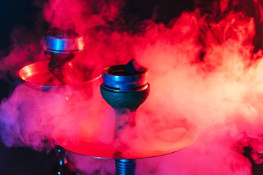 Nargile kasesi, shisha ve kömür renkli ışıklandırmalı dumanlı siyah arka planda yakın plan