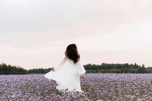 原生花園。女の子は幸せと笑いが咲く畑を駆け抜けています. — ストック写真