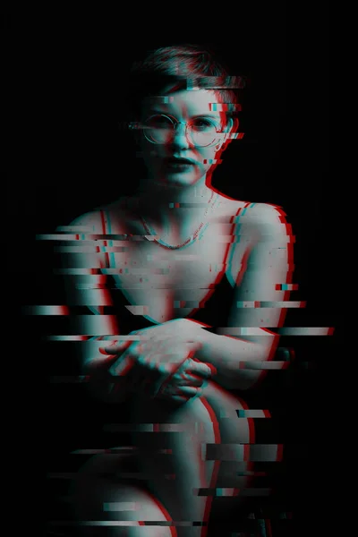 dark portrait of a beautiful girl sitting on a chair. noise is superimposed on the photo. Black and white with glitch effect