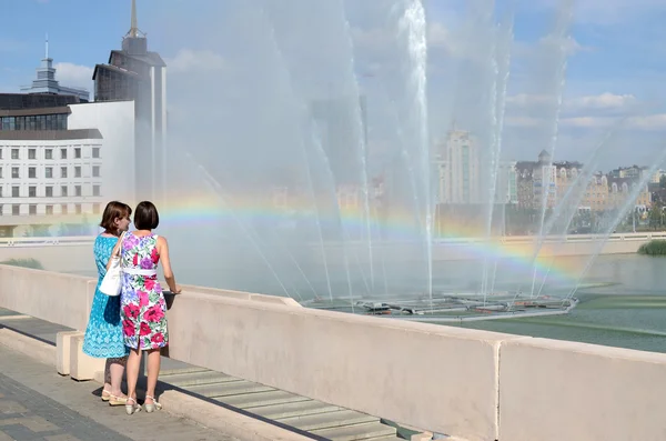 Two women admire a rainbow in the fountain in the lake Bottom Boar, Kazan — Stock Photo, Image