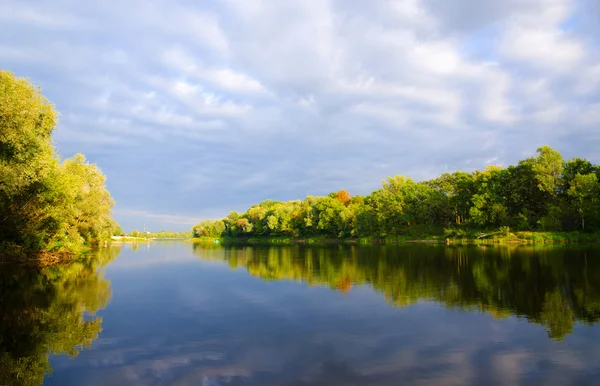 Árboles y nubes reflejados en el río — Foto de Stock