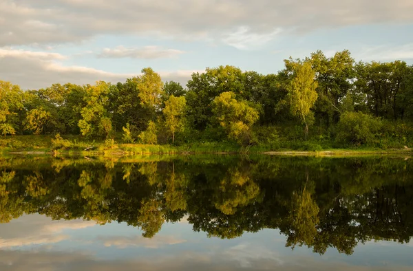 Trees and clouds reflected in the water — Stock Photo, Image