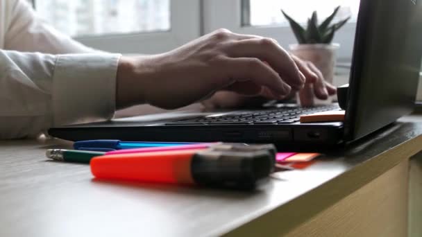 Asztal. Férfi kezek gépelnek egy laptop billentyűzetén. íróanyagok és egy laptop — Stock videók