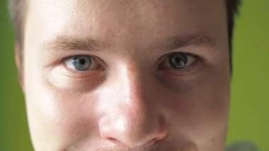 Erkek gözleri yakın plan. Mavi gözler kameraya bakar. Adam göz kırpıyor.
