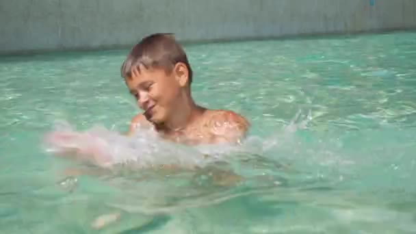 Un ragazzo sta ballando in una piscina all'aperto. Divertiti. rilassarsi nella piscina all'aperto — Video Stock
