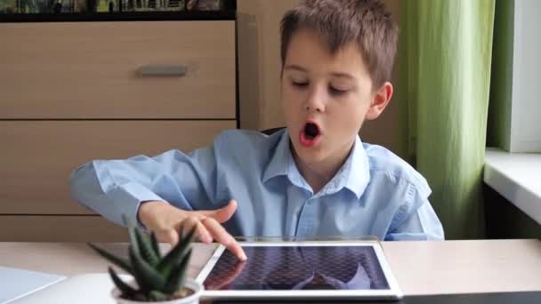 Překvapeně otevře ústa. Student čerpá z grafického tabletu. u stolu studuje chlapec v modré košili — Stock video