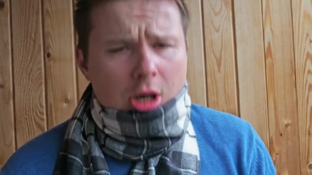 Un hombre con tos fría y se sopla la nariz en un pañuelo. vestido con chaqueta y bufanda. enfermedad, virus, infección — Vídeo de stock