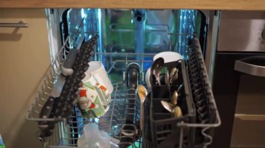 Kadınların elleri bulaşık makinesine kirli bulaşıkları koyar. ev işleri