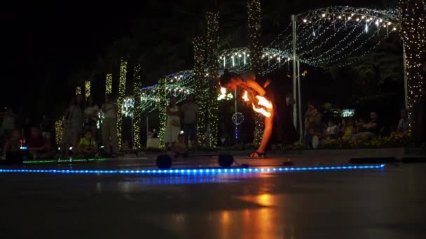 Jalta 2021.08.25. palebná show na náspu. dívka tančící s ohněm. kroutí ohnivou obručí. dovolená sledovat performance.there je mnoho hořících fanoušků v pozadí na nábřeží — Stock video