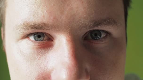 Mannelijke ogen van dichtbij. blauwe ogen kijken naar de camera. de man knippert — Stockvideo