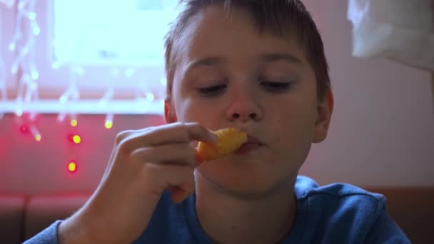 En pojke äter ostpinnar på ett kafé. Osten sträcker sig. Snabbmat. skräpmat — Stockvideo