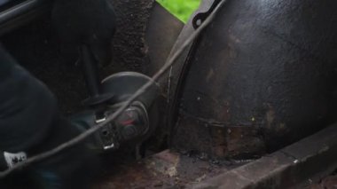 Eldivenli bir adam metali kesici bir diskle testereyle keser. Açı öğütücü. Metalle çalışmak. Diskten parlak ışık fışkırıyor. Araba tamiri. mekanik montaj çalışmalarının mekaniği