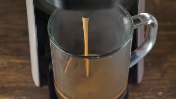 Kaffee wird aus der Kaffeemaschine gegossen. Nahaufnahme von oben. hausgemachter heißer Espresso. Einschenken von frisch gemahlenem Kaffee. morgens trinke ich gerösteten frischen Kaffee — Stockvideo