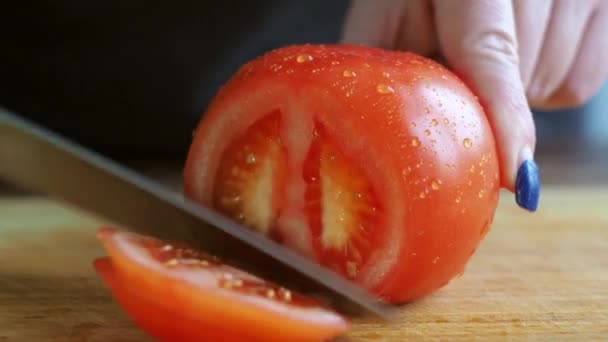 Rebanando tomate de cerca. las manos de mujer cortan hortalizas con un cuchillo — Vídeo de stock