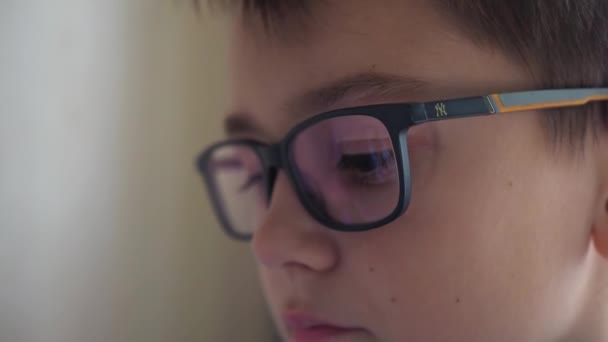 Reflectie in de bril van een tiener. ogen met een close-up gezicht. verblinding van het scherm op de bril — Stockvideo