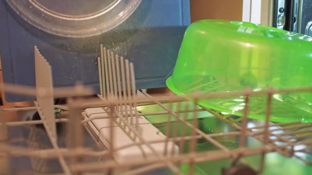 Жіночі руки поклали брудний посуд у посудомийну машину. домашнє завдання — стокове відео