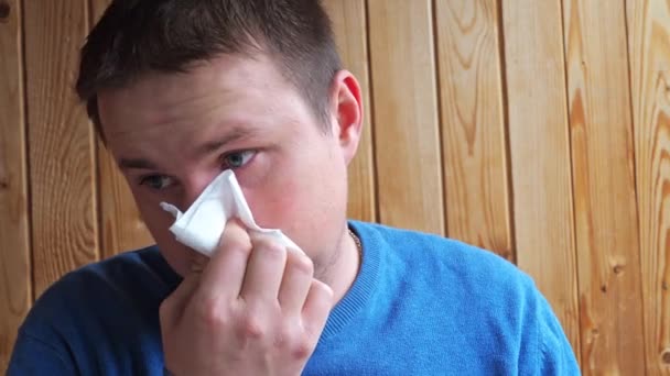 A man with a cold coughs and blows his nose into a handkerchief. He s wearing a sweatshirt . disease, virus, infection — Video Stock