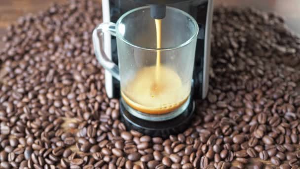 Kaffee wird aus der Kaffeemaschine gegossen. Saatgut liegt herum. hausgemachte Küche mit heißem Americano. Einschenken von frisch gemahlenem Kaffee. morgens trinke ich gerösteten frischen Kaffee — Stockvideo