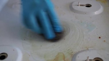Kirli beyaz gaz sobası. Eldivenli eller kiri temizler. Ev ödevi. yakın plan