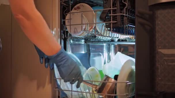 Kadınların elleri bulaşık makinesine kirli bulaşıklar serer. ev işleri — Stok video