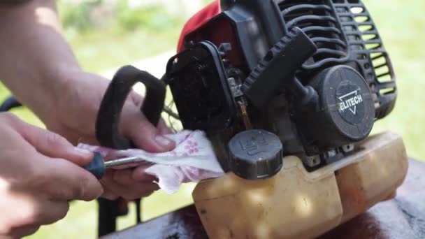 Repair of a lawn mower. a man puts an air filter in the mower. wipes a dirty filter. replacement of the component — Wideo stockowe