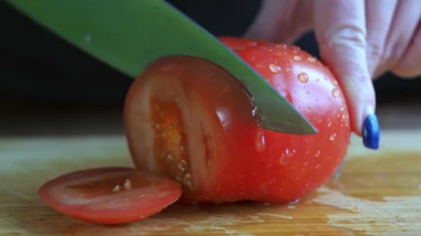 Tomate tranchant gros plan. femmes mains couper des légumes avec un couteau — Video