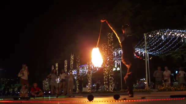 Yalta 2021.08.25. Barajdaki yangın gösterisi. Bir adam ateşle dans eder. Etrafında bir ateş topu çevir. Etrafta bir sürü insan var. — Stok video