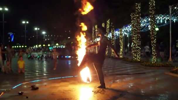 Yalta 2021.08.25. spectacle d'incendie sur le remblai. un homme danse avec le feu. Il y a beaucoup de monde autour. — Video