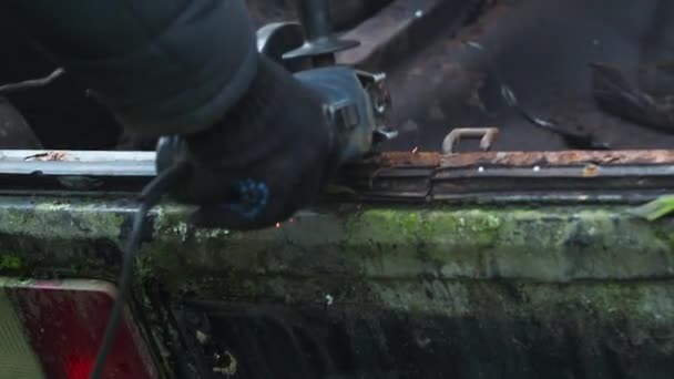 Muž v rukavicích piluje kov s řezacím kotoučem. úhlová bruska. pracuje s kovem. ohnivý sprej. opravna. mechanik mechanických montážních prací — Stock video