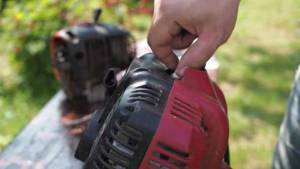 Repair of a lawn mower. a man changes a candle in a mower. replacement of the component — Stock Video