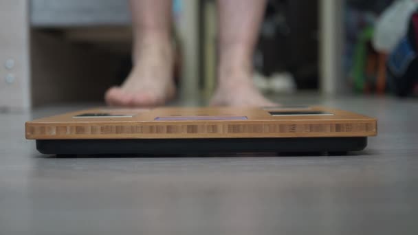 Mens hairy legs stand on the scales. libra in close-up focus. the problem with being overweight — Stockvideo