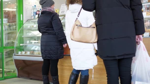 Ženy stojí ve frontě v obchodě. Cukrárna v pekárně. pohled zezadu — Stock video