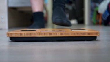 Spor üniformalı bir gencin bacakları terazinin üzerinde duruyor. Libra yakın plan odak noktasında