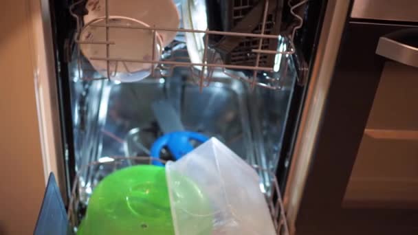 Kobiece ręce układają brudne naczynia w zmywarce. prace domowe — Wideo stockowe