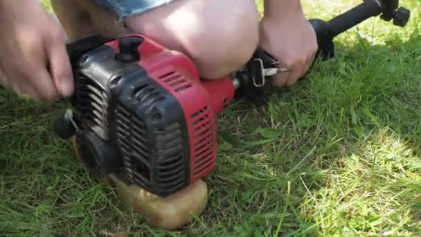 Repair of a lawn mower. the man pulls the starter cord. starts the mower — Stock Video