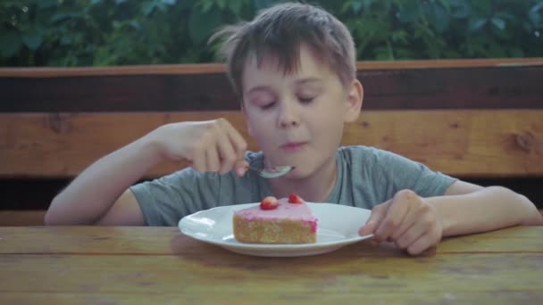 Chłopak próbuje tortu, ciesząc się procesem. podnosi kciuki. pozytywne emocje — Wideo stockowe