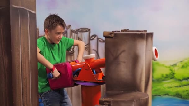 Un băiat trage mingi de la o mitralieră de jucărie. centru de divertisment pentru copii. război joc — Videoclip de stoc