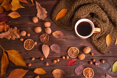 Sonbahar, sonbahar yaprakları, bir fincan sıcak kahve ve ahşap masa arkasında sıcak eşarp, üst manzara, fotokopi alanı. Mevsimlik, sabah kahvesi, pazar dinlendirici ve hayat konsepti..