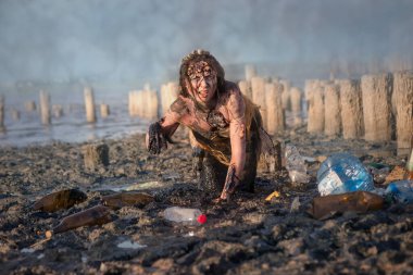 Deniz çevresi ve doğa koruma alanındaki plastik kirliliği kavramı - yakıt yağına bulanmış yaralı bir denizkızı, toprak ve enkazdan muzdariptir..