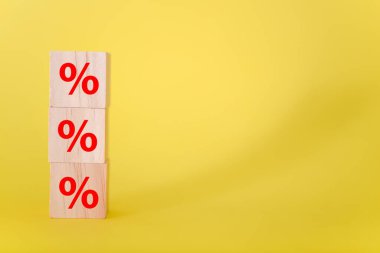 Tahta küplerdeki yüzde işareti sarı arka planda. İş ve finans indirimi veya faiz oranı kavramı.