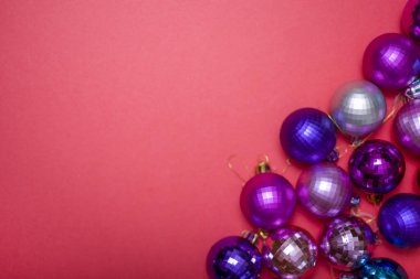 Noel kompozisyonu. Kırmızı süslemeler, kırmızı arka planda Noel ağacı oyuncakları. Düz düzen, üst görünüm, boşluğu kopyala