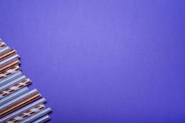 Leylak arkaplanındaki içecekler için renkli pipetler. Yakın plan. Kutlama doğum günü konsepti.