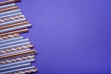 Leylak arkaplanındaki içecekler için renkli pipetler. Yakın plan. Kutlama doğum günü konsepti.