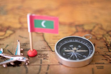 Maldivler bayrağı, uçak ve pusula dünya haritası. Seyahat ve turizm kavramı.