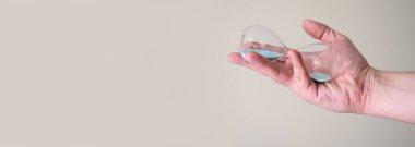 Hafif arka plandaki bir adamın elinde kum saati. Ellerinizdeki zaman kavramı.