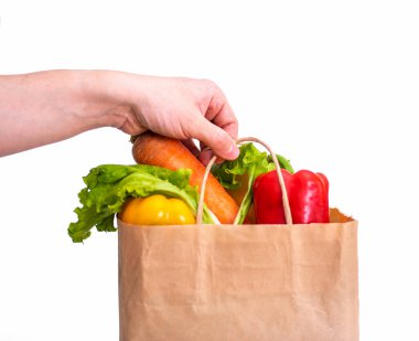 Market alışverişi yapan bir çanta beyaz arka planda bir adamın elini tutuyor. Sağlıklı gıda kavramı.