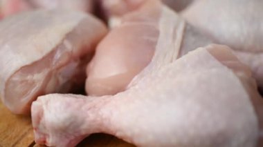 Çiğ, taze tavuk budu, doğrama tahtasında daireler çizerek dönüyor. Tavuk butları şeklinde taze ve diyet mutfağı kavramı..