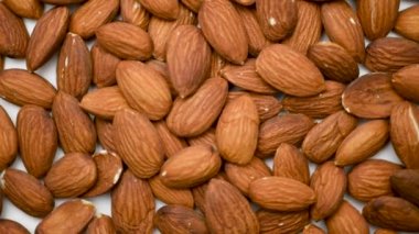 Badem fıstığına yakın çekim. Mineral ve vitamin açısından zengin bir ürün. Çerçevede bir badem döner. Badem taneleri dönüyor.